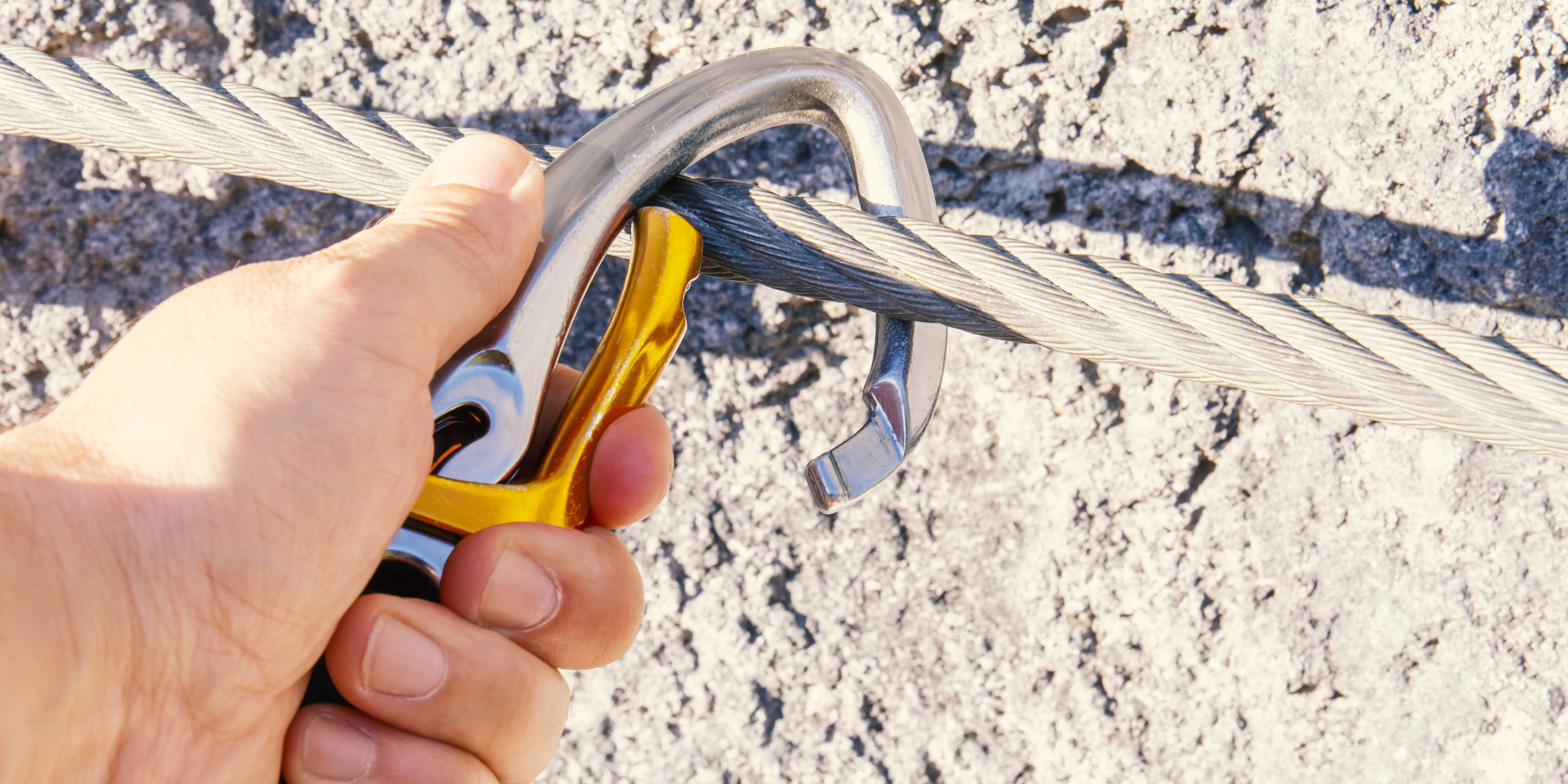 Jemand, der sich mit einem Karabiner sichert